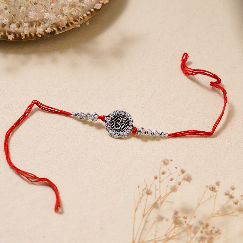 Madhoor Om Rakhi Red Silver-Tone 1 Piece
